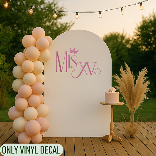 Mis XV vinyl decal with crown in pink, applied on a party backdrop with balloons and cake table, perfect for Quinceañera decoration.