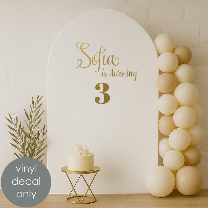 Custom birthday vinyl decal “Sofia is turning 3” in gold letters for kids’ party backdrop decoration