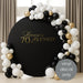 Elegant gold vinyl decal “Lorraine’s 70th & Blessed” on black round backdrop with white and gold balloons for milestone birthday decoration