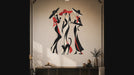 Slow zoom toward three stylized women in sweeping black and red outfits, joined by playful cats