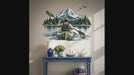 Slow zoom toward a kayaker paddling toward snowy mountains across a blue lake framed by evergreen trees