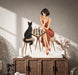 Woman and black cat facing each other across a chessboard wall decal above a cabinet.