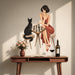 Woman and black cat playing chess wall decal displayed above a console table.